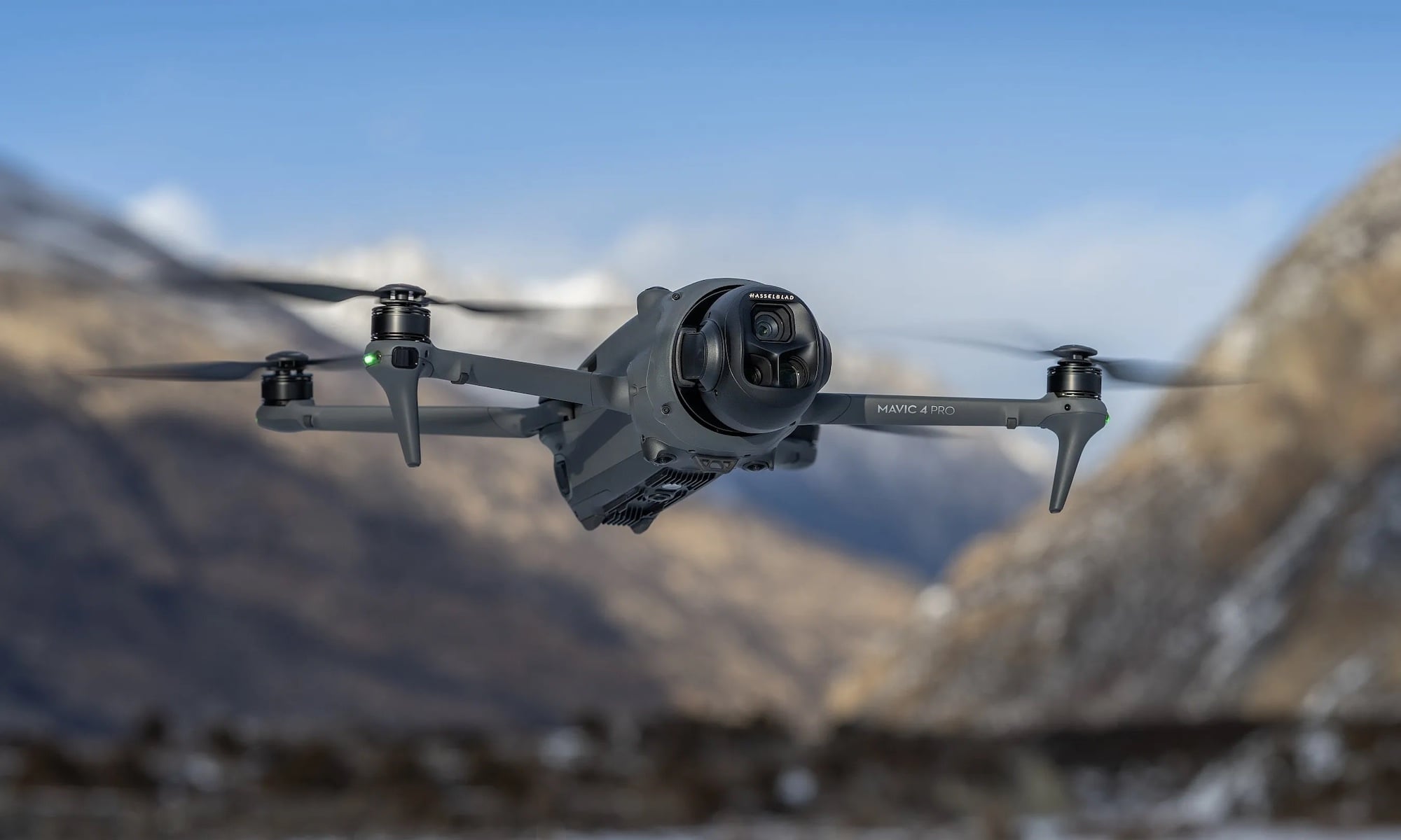 DJI Mavic 4 Pro drone flying in a mountain landscape